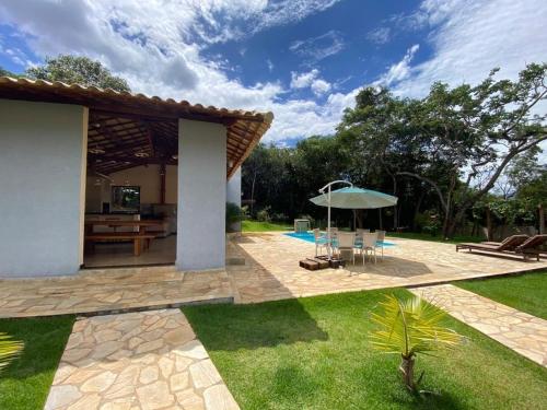 a patio with a table and an umbrella at Casa Jatobá da Serra in Serra do Cipo
