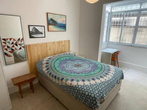1 dormitorio con 1 cama con edredón en NOVO LOFT silencioso quadra da PRAIA Copacabana, en Río de Janeiro