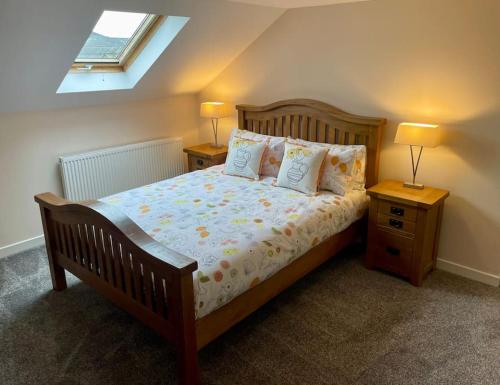 a bedroom with a bed with two night stands and two lamps at Vennel Street Apartments in Stewarton