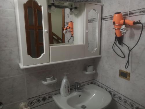 La salle de bains est pourvue d'un lavabo et d'un miroir. dans l'établissement Antico Portale - Host Roberto, à Regalbuto