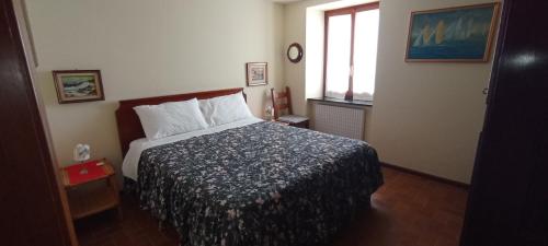 um quarto com uma cama e uma janela em In Sciâ Costa em Bogliasco