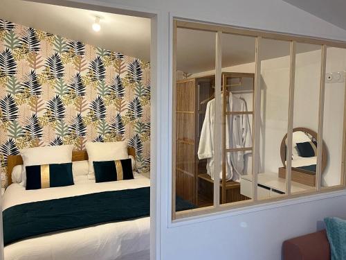 Bobital的住宿－Côté Jardin，一间卧室配有一张带镜子的床和一间更衣室