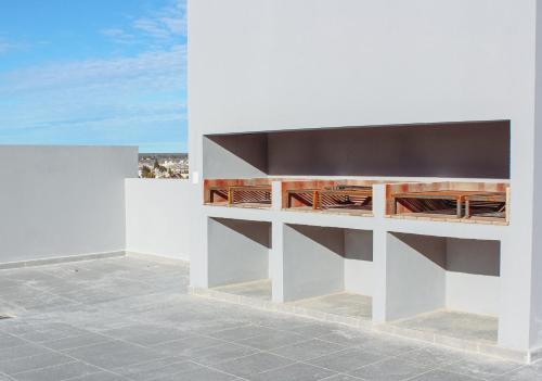 a white wall with wooden shelves on a patio at CQ MITRE in Puerto Madryn