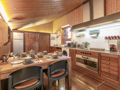 une cuisine avec une table en bois et deux chaises dans l'établissement Chalet de luxe avec sauna, cheminée et WiFi à Val-d'Isère - FR-1-694-17, à Val dʼIsère