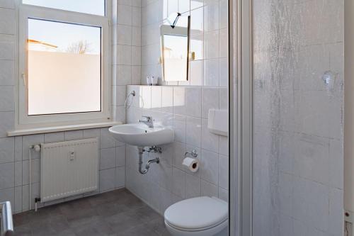 La salle de bains est pourvue de toilettes, d'un lavabo et d'un miroir. dans l'établissement Nauticus, à Rostock