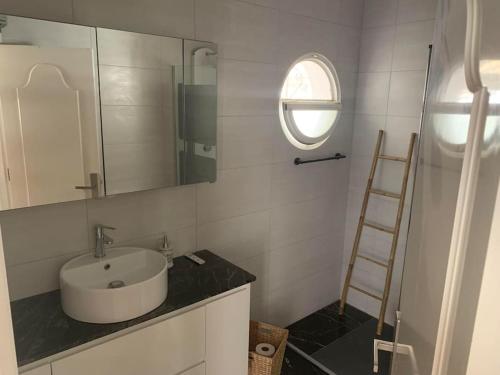 ein Badezimmer mit einem Waschbecken, einem Spiegel und einer Leiter in der Unterkunft Schönes Ferienbungalow in Los Altos Torrevieja in Torrevieja