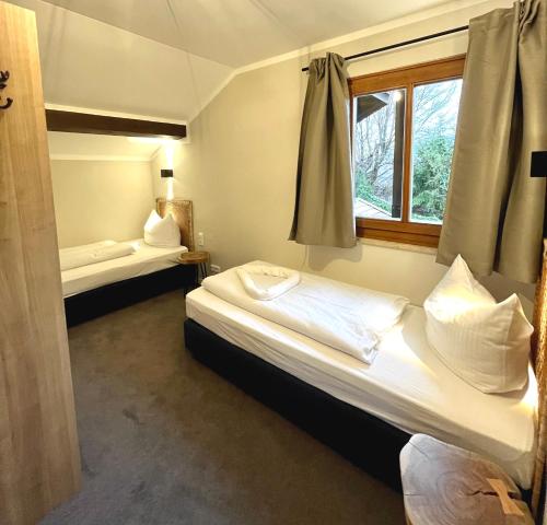 a room with two beds and a window at Wiefarn Apartments - Ferienwohnungen in Bad Wiessee am Tegernsee in Bad Wiessee
