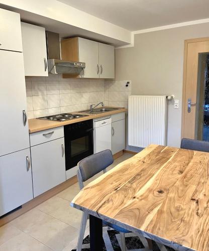 a kitchen with a wooden table in a kitchen at Wiefarn Apartments - Ferienwohnungen in Bad Wiessee am Tegernsee in Bad Wiessee