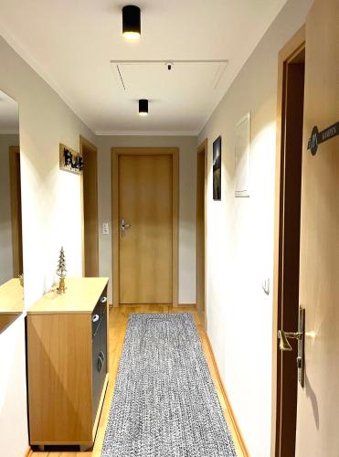a room with a kitchen and a hallway with a rug at Wiefarn Apartments - Ferienwohnungen in Bad Wiessee am Tegernsee in Bad Wiessee