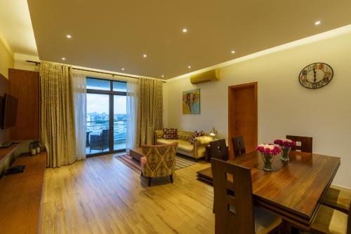 a living room with a table and a couch and a clock at Carlsen Residence in Colombo