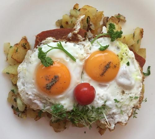 two fried eggs on a plate with potatoes at Sternenhimmel Gamlitz FeWo 3 SZ in Gamlitz