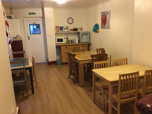 a kitchen and dining room with wooden tables and chairs at Sea View Guest House in Hartlepool