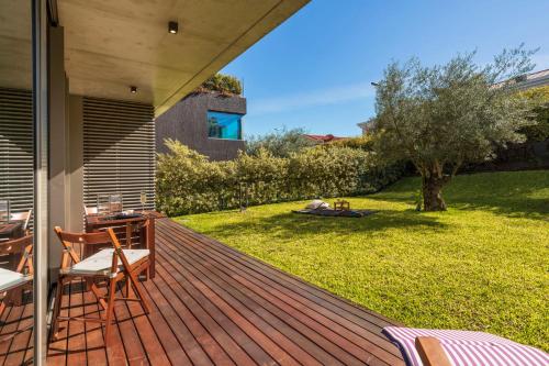 una terraza de madera con mesa y sillas en un patio en Savoy Residence Casa Branca I by An Island Apart, en Funchal