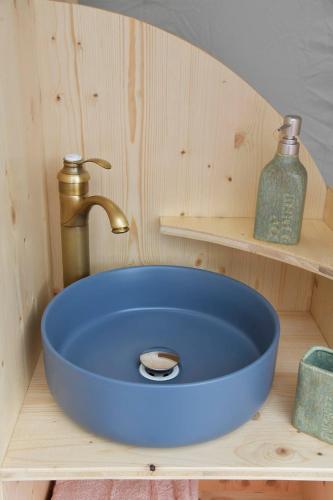 - un lavabo bleu avec robinet dans la salle de bains dans l'établissement Bulle Ecureuil, à Quarré-les-Tombes