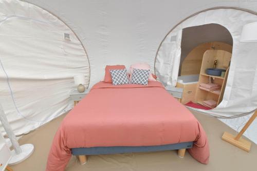 een slaapkamer met een bed in een tent bij Bulle Ecureuil in Quarré-les-Tombes
