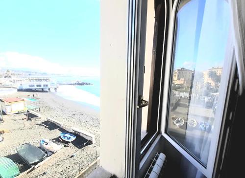 a window with a view of a beach and the ocean at Hotel Castello Miramare in Genova