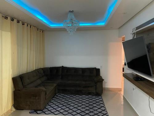 een woonkamer met een bank en een flatscreen-tv bij Cantinho Almeida in Alto Paraíso de Goiás