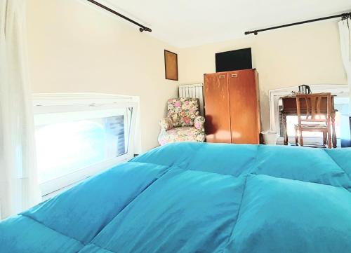 a bedroom with a blue bed and a window at Hotel Castello Miramare in Genova