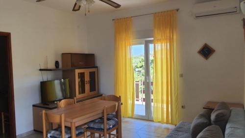 a living room with a couch and a table and a television at Apartments Irena in Božava