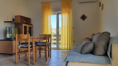 a living room with a couch and a table and chairs at Apartments Irena in Božava