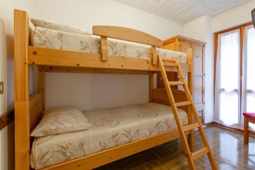 two bunk beds in a room with a ladder at Hotel Biancospino in Lanzada