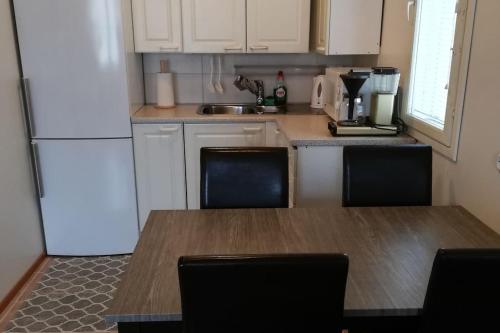 a kitchen with a wooden table and a refrigerator at Cosy studio apartment near by Ideapark in Lempäälä