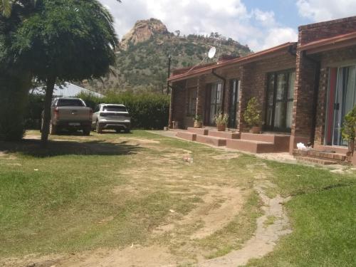 a house with a mountain in the background at Lion Rock View Guesthouse in Maseru