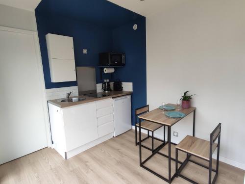 une petite cuisine avec une table et des chaises dans une pièce dans l'établissement La cabane au fond du jardin - 300m de la plage, à Saint-Malo