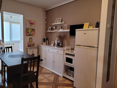 a kitchen with a white refrigerator and a table at Relax Apartament in Constanţa