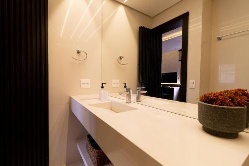 baño con 2 lavabos y espejo grande en Vossa Bossa Flat Jardins, en São Paulo