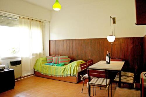 1 dormitorio con 1 cama, mesa y sillas en Pinamar departamento, edificio Atlántico en Pinamar