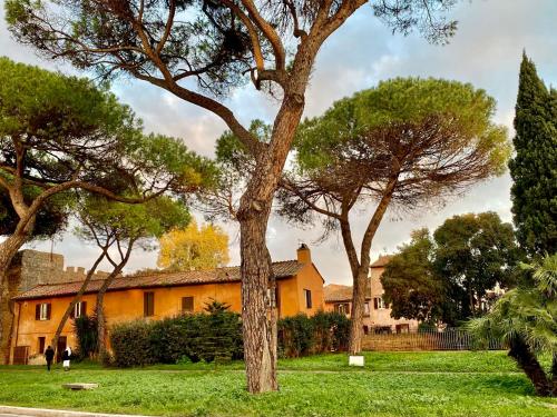 un gruppo di alberi di fronte a una casa di La casetta di Giulio II a Ostia Antica