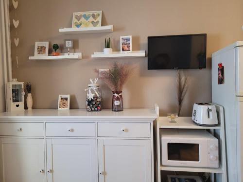 a white cabinet with a tv on a wall at Relax Apartament in Constanţa