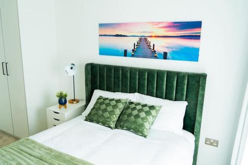a bed with a green headboard in a bedroom at Lavish 2 Bedroom Apartment in Colindale