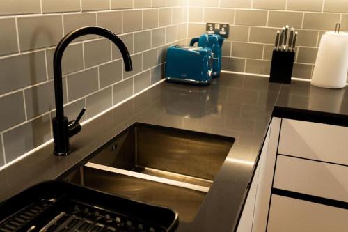 Colindale的住宿－Lavish 2 Bedroom Apartment，厨房水槽和柜台上的水龙头