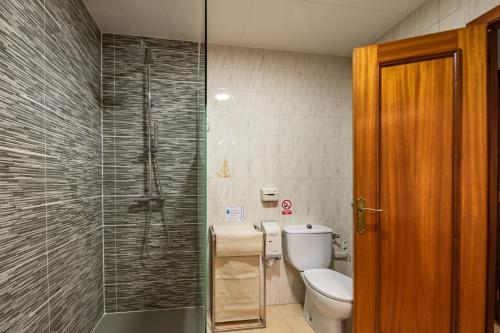 a bathroom with a toilet and a glass shower at Hotel Sausa in Vilafreser