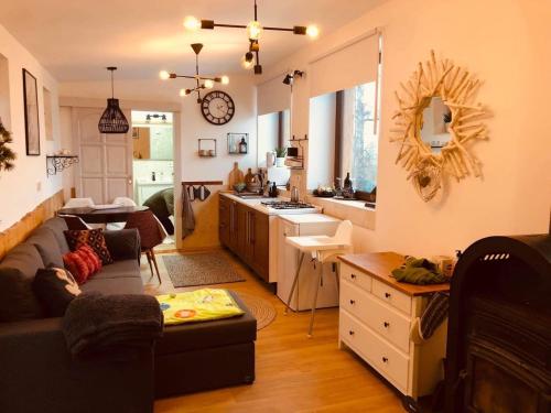 a living room with a couch and a kitchen at Larix Mátra Vendégház in Matraszentlaszlo