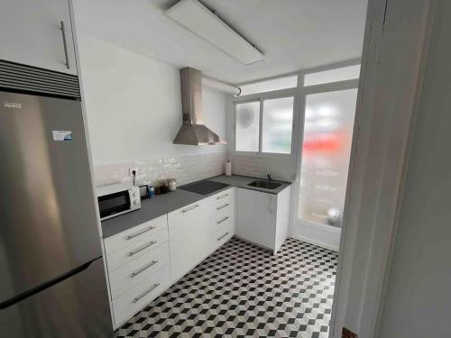uma cozinha com armários brancos e um piso xadrez em Apartamento en Granada em Granada