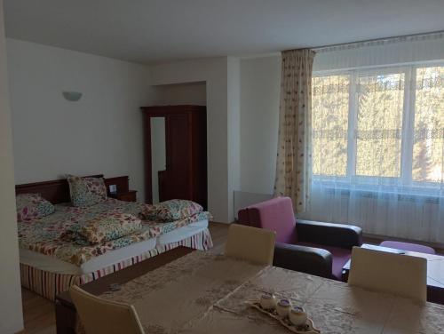 - une chambre avec un lit, une table et des chaises dans l'établissement апартамент Дани 501 Stream tesort, à Pamporovo