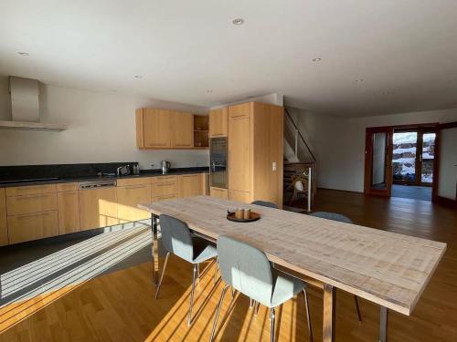 a large kitchen with a wooden table and chairs at Wunderschönes Gästehaus mit grandioser Aussicht in Gempen