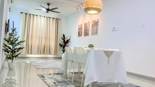 Un comedor con paredes blancas y un ventilador de techo. en MIMPI HOMESTAY - 4 Bedroom and Pool, en Kuala Terengganu