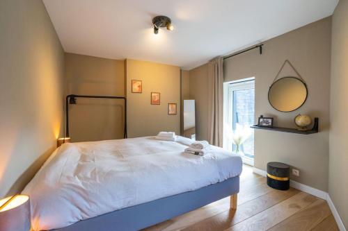 a bedroom with a large bed and a window at Le Comble Amoureux in La Roche-en-Ardenne