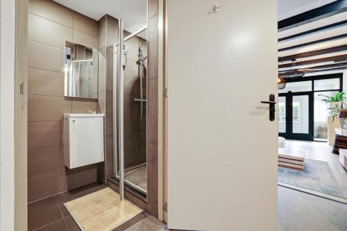 een badkamer met een douche en een glazen deur bij Prachtig appartement in hartje Sneek in Sneek