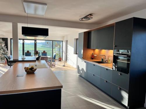 eine Küche mit schwarzen Schränken und ein Wohnzimmer in der Unterkunft Maison petite Suisse luxembourg in Berdorf