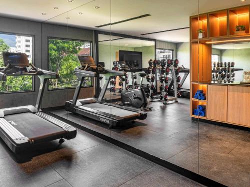 a gym with several tread machines in a room at ibis Chiang Mai Nimman Journeyhub in Chiang Mai