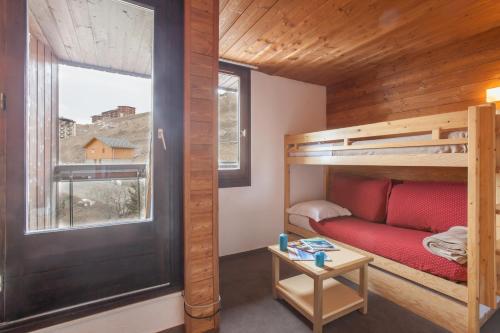 レ・メニュアールにあるRésidence Pierre & Vacances Les Combesの二段ベッド1組、窓が備わる小さな客室です。