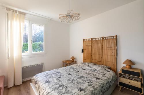 1 dormitorio con cama y ventana en Appartement très calme, terrasse & jardin en ville, en Besançon