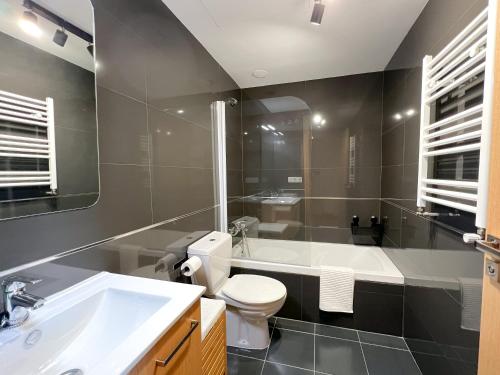 uma casa de banho com uma banheira, um WC e um lavatório. em Apartamento de diseño con Gym y Piscina em Castellón de la Plana