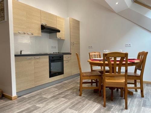 une cuisine et une salle à manger avec une table et des chaises dans l'établissement Le cosy de la vologne, à Gérardmer