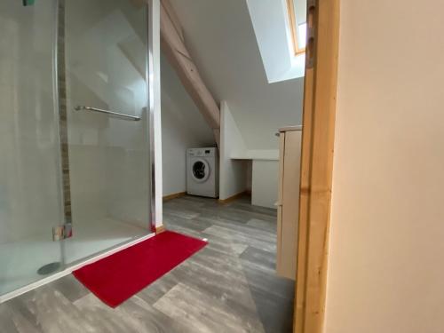 uma casa de banho com um chuveiro e um tapete vermelho em Le cosy de la vologne em Gérardmer